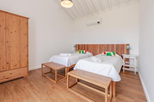 a room with two beds and a cabinet at Casas do Forneiro - T2 in Nordeste