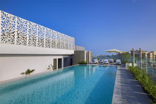 a swimming pool on the roof of a building at Tumbi Hotel Dubai The Palm,Tapestry Collection Hilton in Dubai