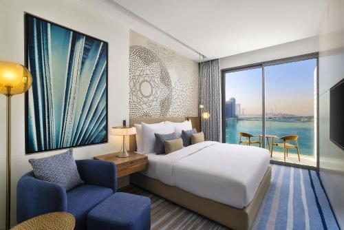 a hotel room with a bed and a large window at Tumbi Hotel Dubai The Palm,Tapestry Collection Hilton in Dubai
