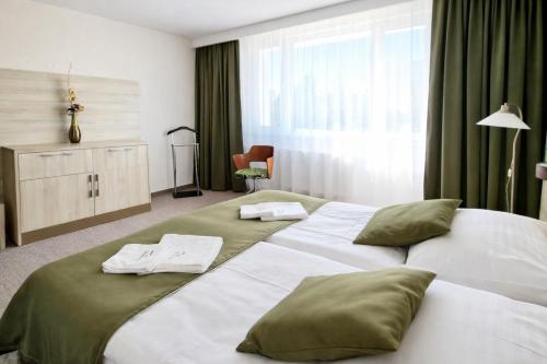a hotel room with two beds with green pillows at Hotel Kristína in Dubnica nad Váhom