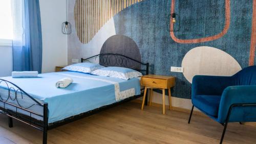 a bedroom with a bed and two blue chairs at New Villa Oasis in Imotski