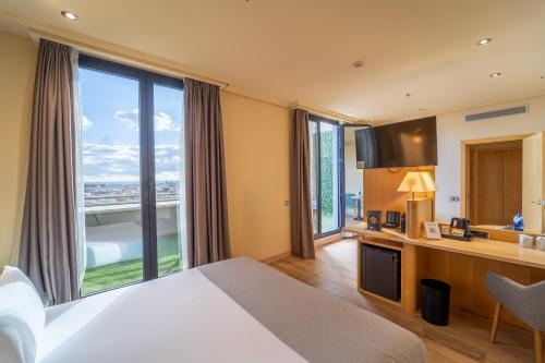 a hotel room with a bed and a large window at Abba Madrid in Madrid