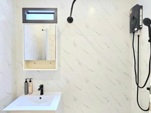 a white bathroom with a sink and a mirror at The Mellow at Sathorn in Chinatown