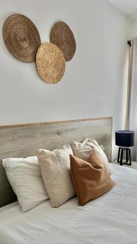 Sal e Luz Apartment في سانتا ماريا: سرير مع وسائد وقبعات معلقة على الحائط