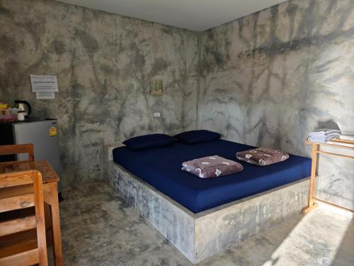 a bedroom with a bed with two pillows on it at โรงแรมบ้านสวนบางภูมิ in Ban Pa Kathum (1)