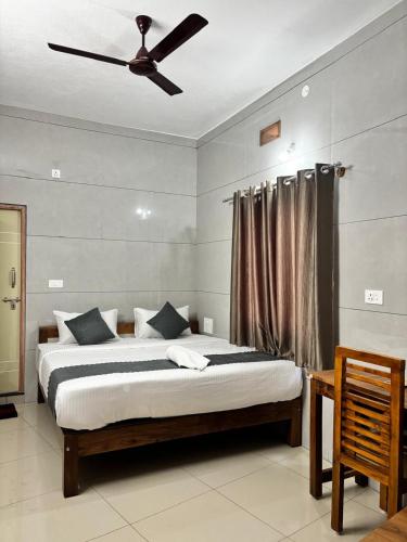 a bedroom with a bed with a ceiling fan at Nest Inn in Suntikoppa