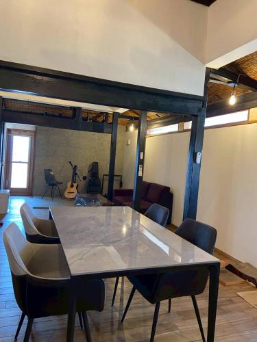 a dining room with a table and chairs in a room at The Kominka-house Olive in Sano
