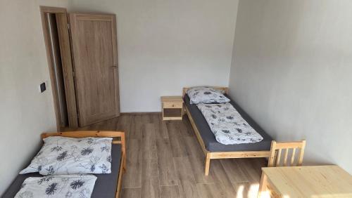 a room with two beds and a table and a door at Apartmán Mírová 472 B in Milovice
