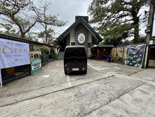 a van parked in a parking lot in front of a building at Lualhati Homestay in Baguio