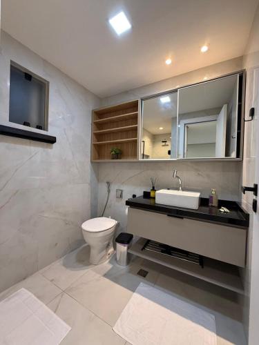 a bathroom with a toilet and a sink and mirror at Apartamento Exclusivo com Vista Mar no Number One Flat in São Luís