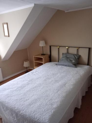 a bedroom with a large white bed in a attic at Herrgårdsvillan in Tjurkö