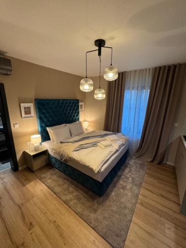 a bedroom with a large bed with two lights at 5 Crowns - Osijek - Free EV - Self check in - Pool in Osijek