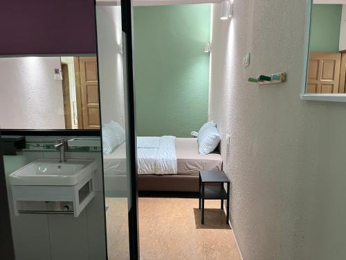 a bathroom with a bed and a sink and a mirror at Puzzle House in Taiping