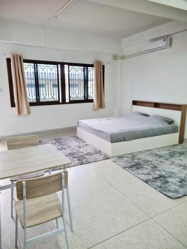 a bedroom with a bed and a table and chairs at 57 hua hin in Hua Hin