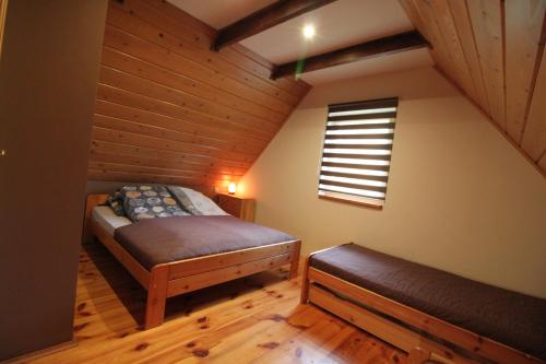 ein Dachgeschosszimmer mit Bett und Fenster in der Unterkunft Bukowinka in Krempna