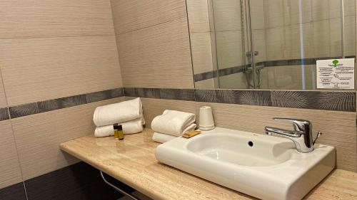 a bathroom with a sink and a mirror at Hotel & Appartements Acqua Dolce in Porticcio