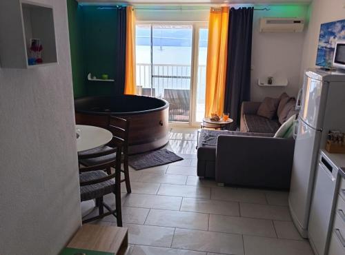 a living room with a bath tub and a kitchen at Apartment Sutalo with Hot Tub in Komarna