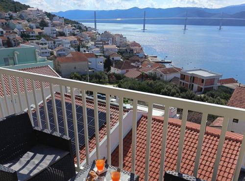 a balcony with a view of the water and a city at Apartment Sutalo with Hot Tub in Komarna