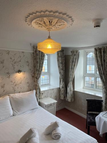 a bedroom with a bed and a chandelier at Riverside Guesthouse in Charlestown