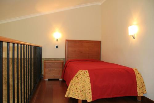 a bedroom with a red bed and a dresser and lights at Hotel Rural Quinta de Sao Sebastiao in Barroselas