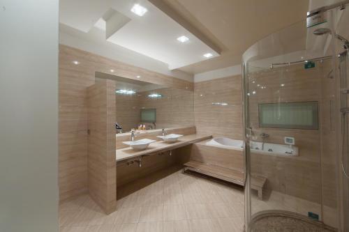 ein großes Bad mit 2 Waschbecken und einer Dusche in der Unterkunft Gorky Hotel in Nischni Nowgorod