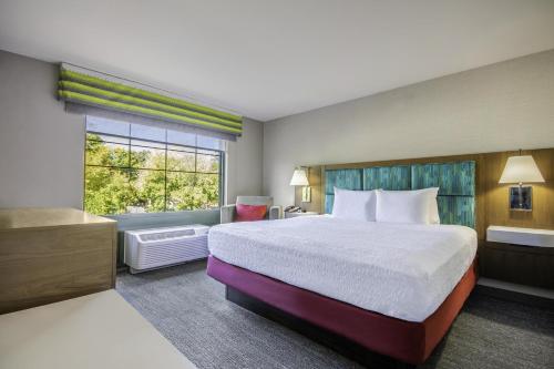 a hotel room with a large bed and a window at Hampton Inn East Aurora, NY in East Aurora