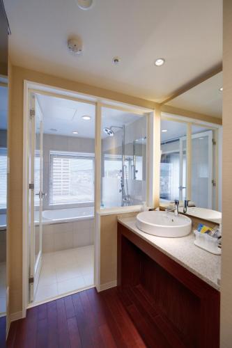 a large bathroom with a sink and a shower at Hotel Metropolitan Akita in Akita
