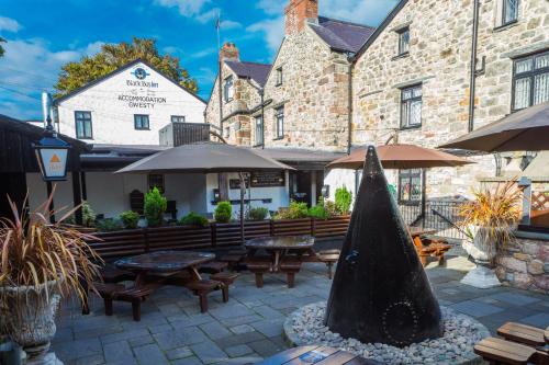 patio ze stołami i krzesłami oraz budynek w obiekcie The Black Boy Inn w mieście Caernarfon