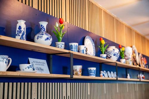 a shelf filled with blue and white vases and plates at Giethoorn Old Art Hotel in Giethoorn