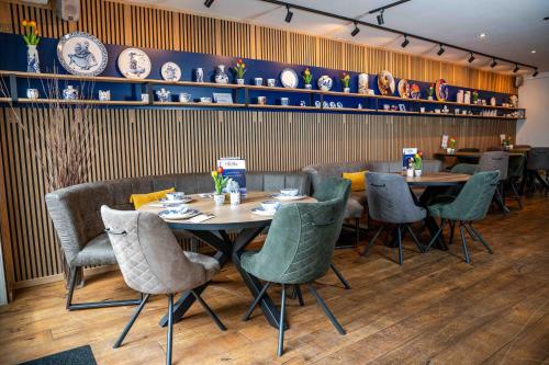 a dining room with tables and chairs and plates on the wall at Giethoorn Old Art Hotel in Giethoorn