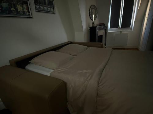 a bed in a bedroom with a clock on the wall at Charmant studio Hyper centre in Dreux