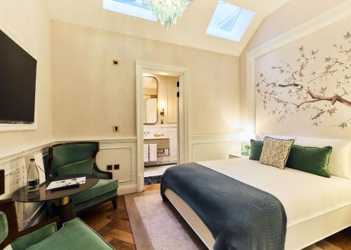 a bedroom with a bed and a desk and a tv at 2 Chesham Hotel in London