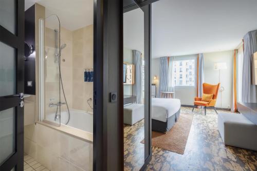a hotel room with a bed and a bathroom at DoubleTree by Hilton Paris Boulogne in Boulogne-Billancourt