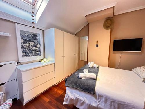 a bedroom with a large bed and a tv at Apartamento El Rey in Colombres