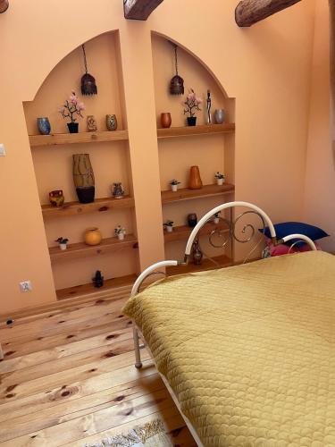 a bedroom with a bed and shelves with vases at Marokanski domek in Mielnik