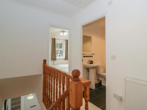 a staircase leading to a bathroom with a sink at 42 Ynys Y Nos in Neath