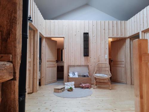a living room with wooden walls and a chair at Grain d'orge et cornouiller in Bulson