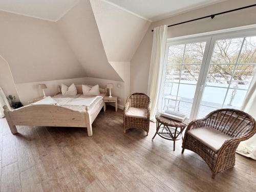 a bedroom with a bed and two chairs and a window at Beauty Concept SPA in Lübeck