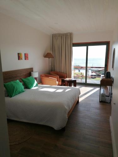 a bedroom with a large bed and a large window at Salga Lodge in Angra do Heroísmo
