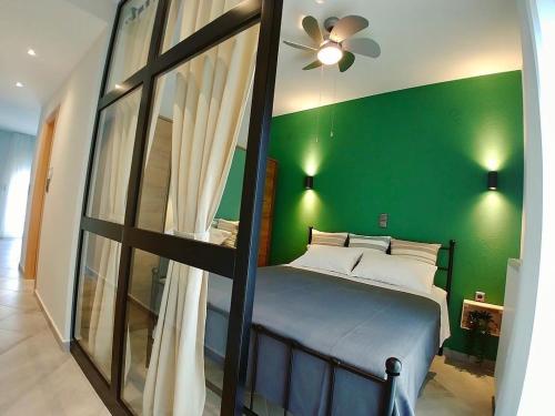 a bedroom with a green wall and a bed at 48 Downtown Lofts in Nea Peramos