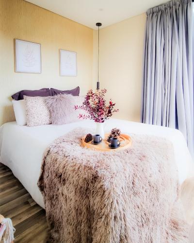 a bedroom with a bed with a table with flowers on it at Villa no Jardim dos Aromas in Gião
