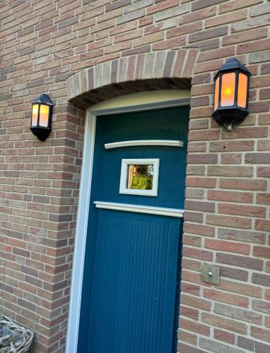 a blue door on a brick building with a window above it at Ferienhaus Leegwater in Munkmarsch