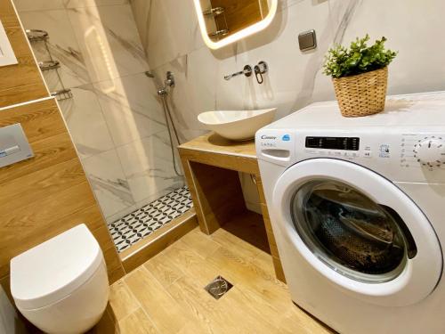 a bathroom with a washing machine and a shower at 48 Downtown Lofts in Nea Peramos