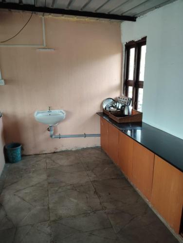 a bathroom with a white sink in a room at Armaan's mud mart in Kodaikānāl
