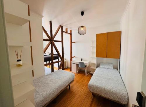 a room with two beds and a desk in it at Lisboa Hostel in Lisbon