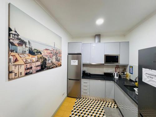 a kitchen with white cabinets and a black and yellow tile floor at Lisboa Hostel in Lisbon
