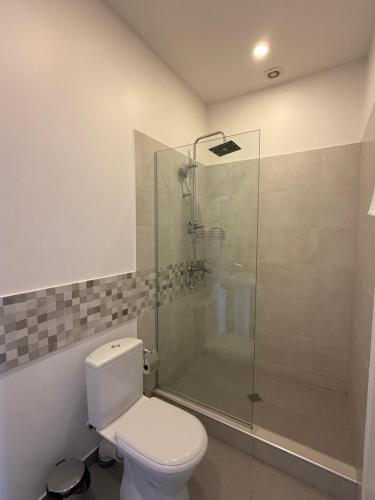 a bathroom with a toilet and a glass shower at Hotel Vista in Tbilisi City