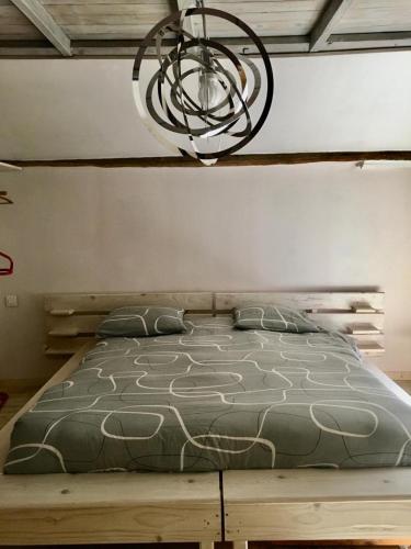 a bedroom with a bed and a chandelier at Les capucins de Provins Maison in Provins
