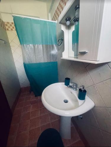 a bathroom with a white sink and a mirror at Klapidis apartments in Kriopigi