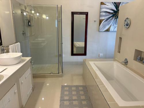 a bathroom with a tub and a sink and a shower at The Suite in Stanford